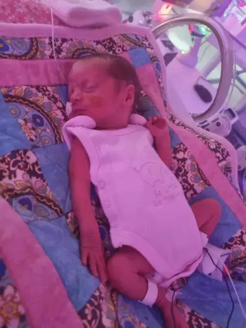 2 pack pink elephant and star incubator vests on a premature baby