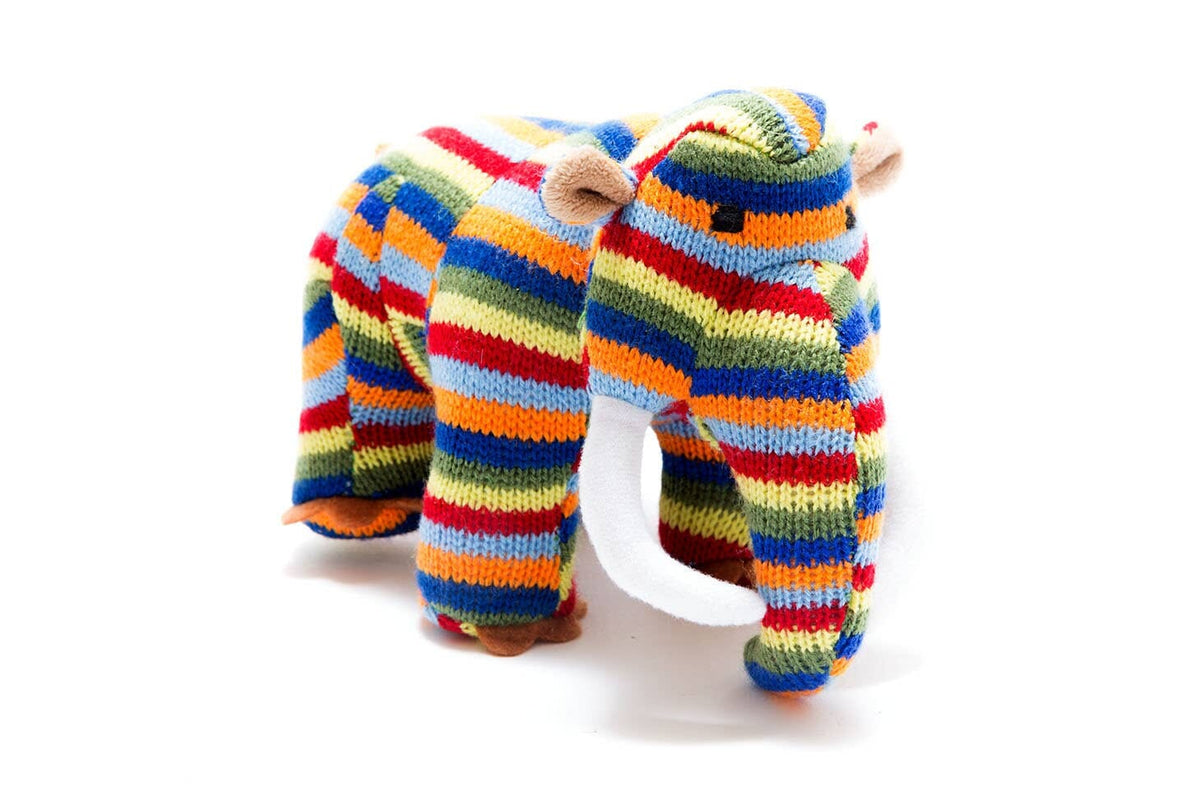 A knitted stuffed elephant toy with horizontal rainbow stripes in red, orange, yellow, green, blue, and white, featuring brown ears and trunk base, photographed on a white background.