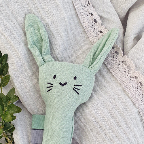 Light blue bunny toy on a textured fabric background