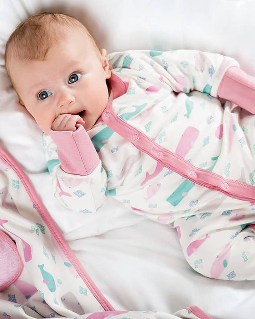 Newborn baby in a sleepsuit with whales on