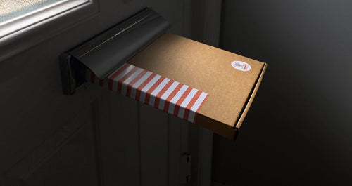 Cardboard box with a striped brown and white label on a dark surface