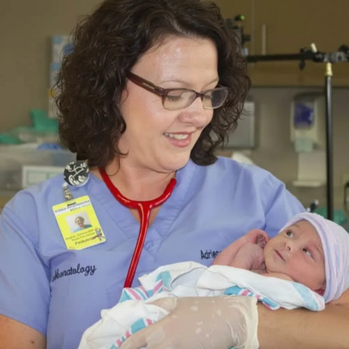Nurse holding a newborn baby in a hospital setting