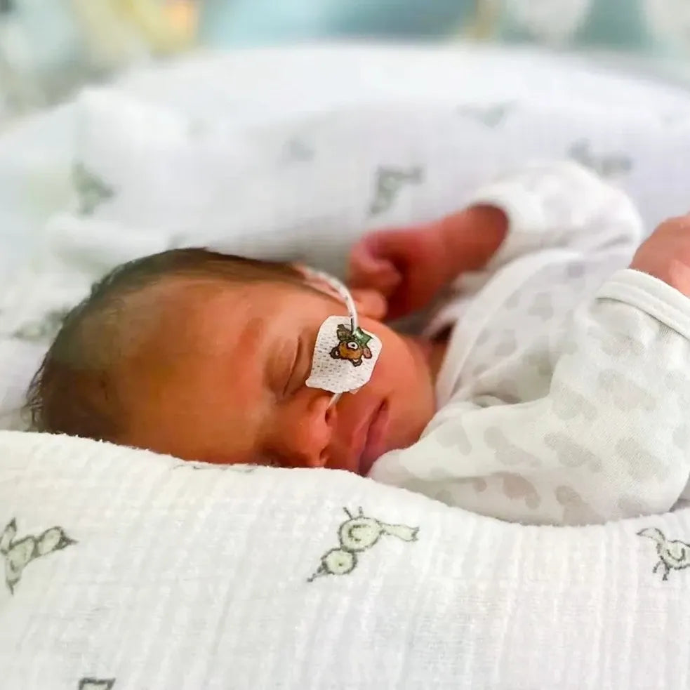 Newborn premature baby lying on a white blanket in  NICU.